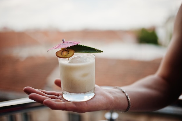 Alcoholic cocktail in glass on hand of barman