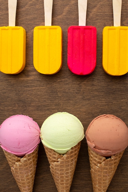 Free photo aligned ice cream on sticks and cones