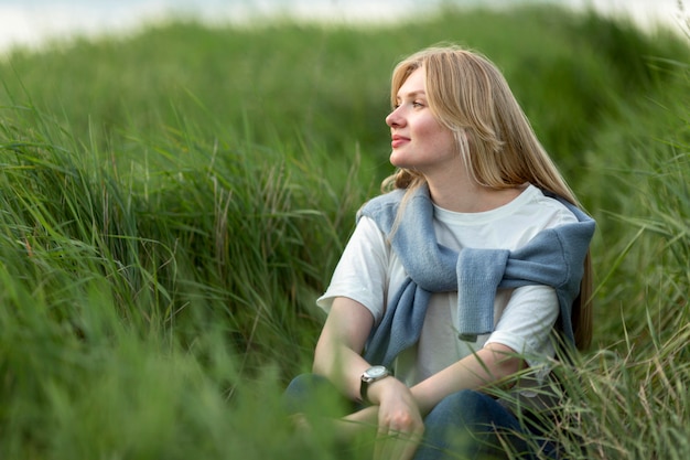 Free photo alluring woman posing in grass