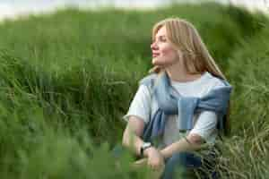 Free photo alluring woman posing in grass