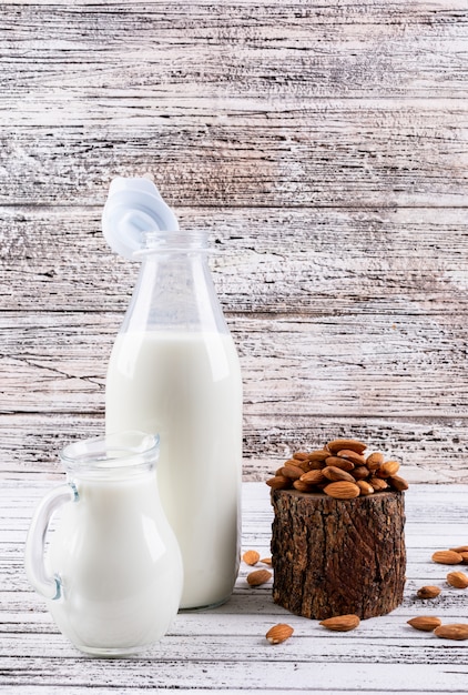 Free photo almond and milk with piece of wood