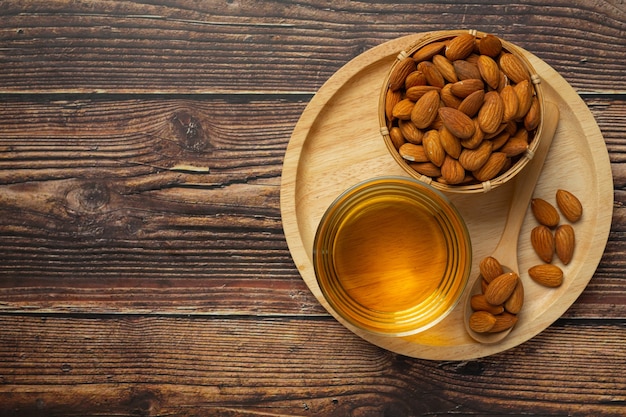 Almond oil in bottle on dark wood background