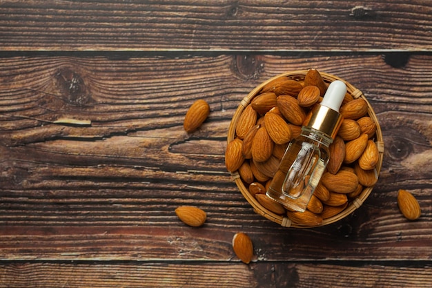 Free photo almond oil in bottle on dark wood background