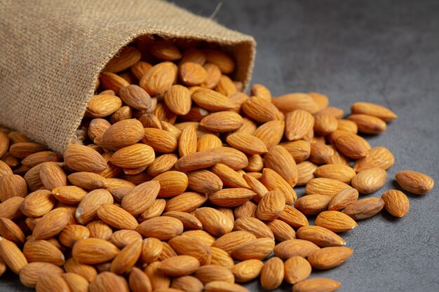 Almonds in bag from sackingl on dark background