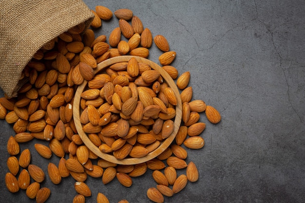 Almonds in bowl on dark background