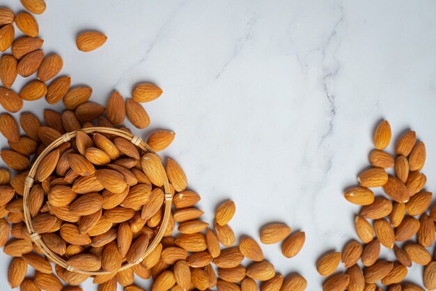 Almonds in bowl on marble background