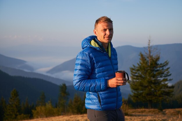 Alone man walking in the mountains early autumn