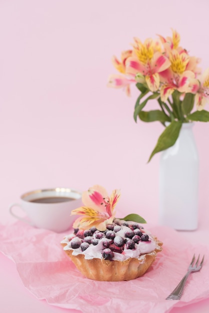 Free photo alstroemeria flower on fruit tart consisting of blueberries