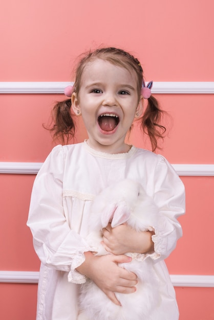 Amazed girl standing with rabbit 