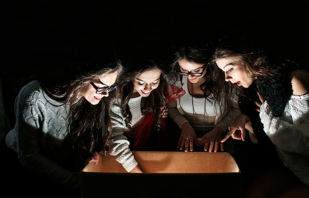 Free photo amazed teens examining an open box