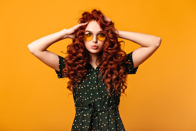 Free photo amazed white girl playing with curly hair. red-haired caucasian woman looking at camera.