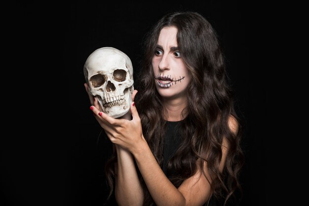 Amazed woman holding skull