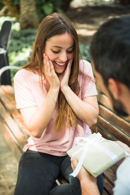 Free photo amazed woman looking at valentine gift bought by her boyfriend