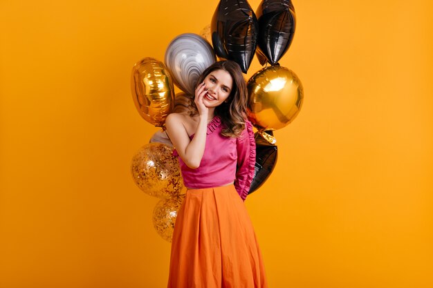 Amazing birthday woman posing on orange wall