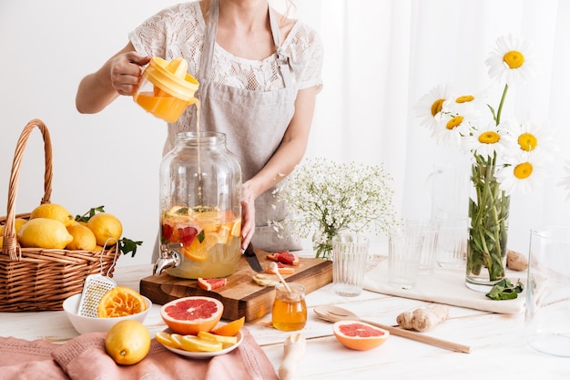 Amazing concentrated woman cooking citrus beverage.