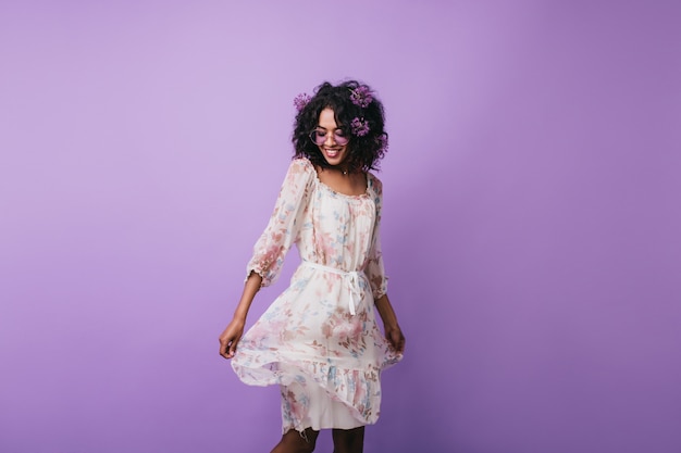 Amazing dark-haired girl posing in trendy summer dress. Portrait of gorgeous african woman dancing with inspired smile.