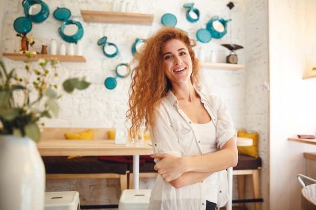 Free photo amazing laughing redhead young lady standing in cafe