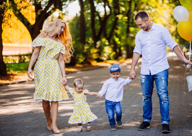 Free photo amazing parents have fun with their two children walking in the park