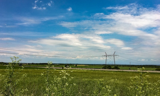 Free photo amazing shot of a beautiful meadow on a transmission tower background