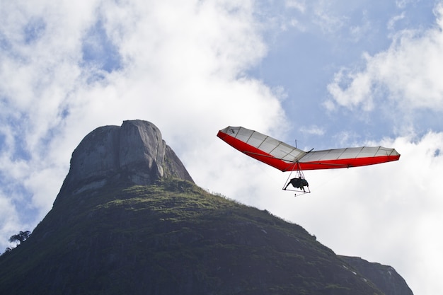 Free photo amazing shot of human flying on a hang glider