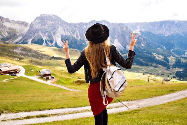 Free Photo amazing traveling experience image of beautiful stylish woman posing back and looking at breathtaking mountains view