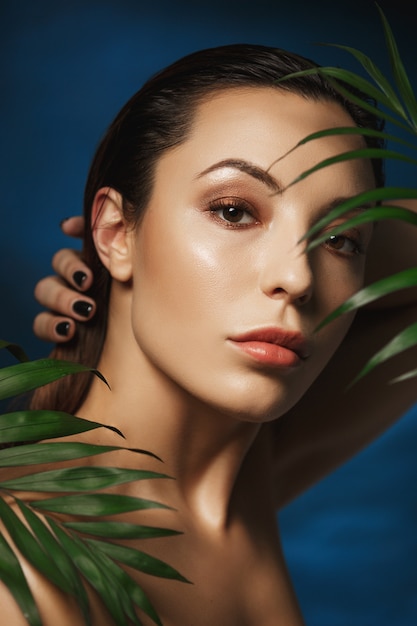 Amazing woman with wet hair. Holding left hand on neck.