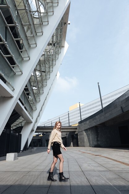 Amazing young blonde lady walking outdoors. Looking aside.