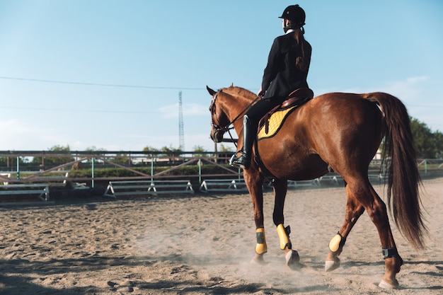 Free photo amazing young cowgirl sitting on horse outdoors