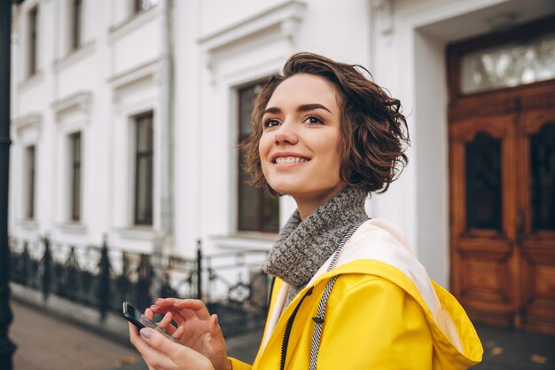 Amazing young woman dressed in raincoat