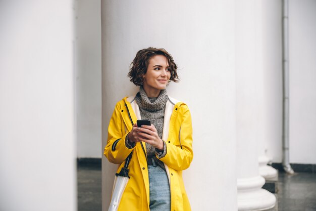 Amazing young woman dressed in raincoat.