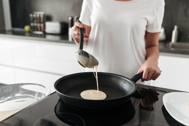 Amazing young woman standing at the kitchen in home