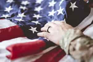 Free photo american soldier mourning and praying with the american flag in front of him