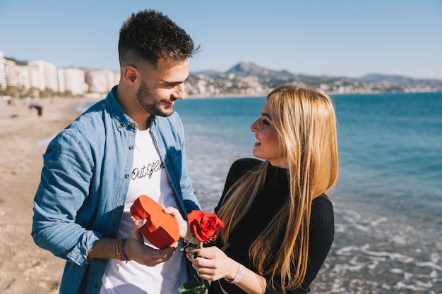 Amorous couple with gifts on beach