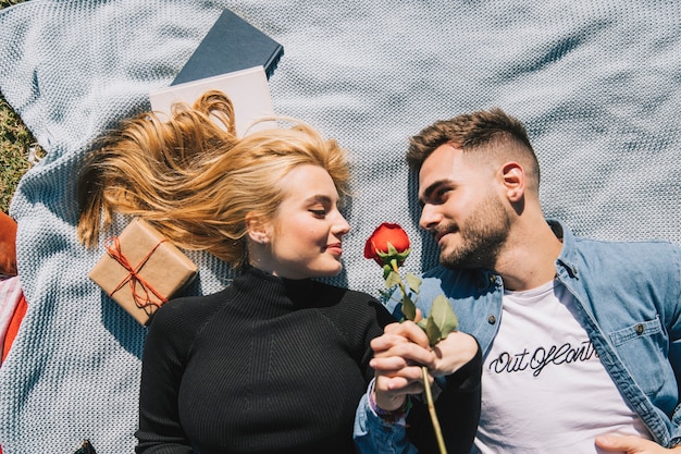 Free photo amorous couple with rose on plaid