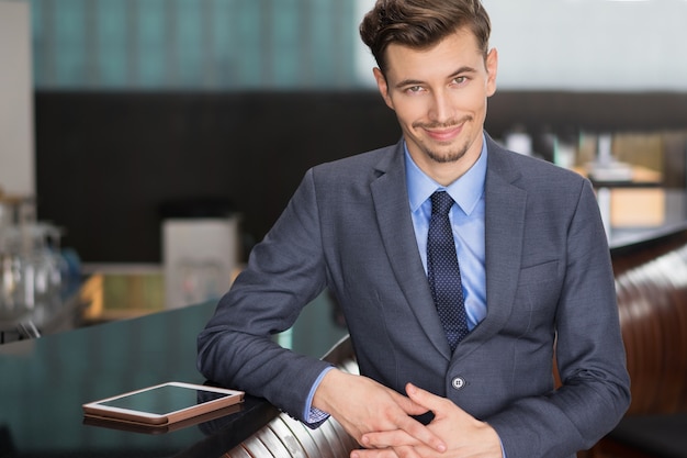 Free photo amusing young businessman standing at cafe counter