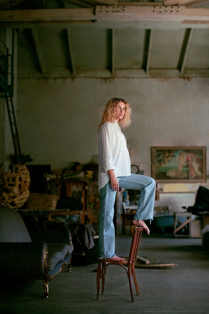 Free photo analog portrait of beautiful woman posing indoors on a chair