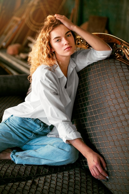 Free photo analog portrait of beautiful woman posing indoors on a couch