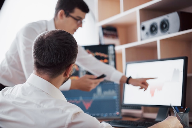 Free photo analyzing data. close-up of young business team working together in creative office while young woman pointing on the data presented in the chart with pen