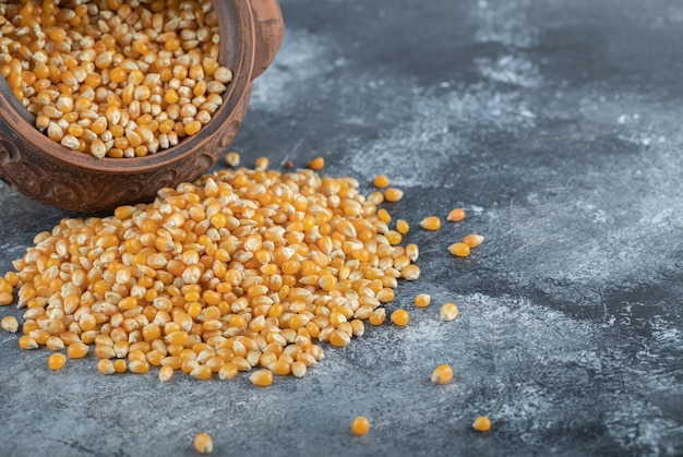 An ancient bowl full of uncooked popcorn seeds.