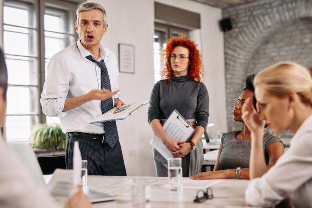 Free Photo angry businessman feeling disappointed with business reports and scolding his team during a meeting in the office