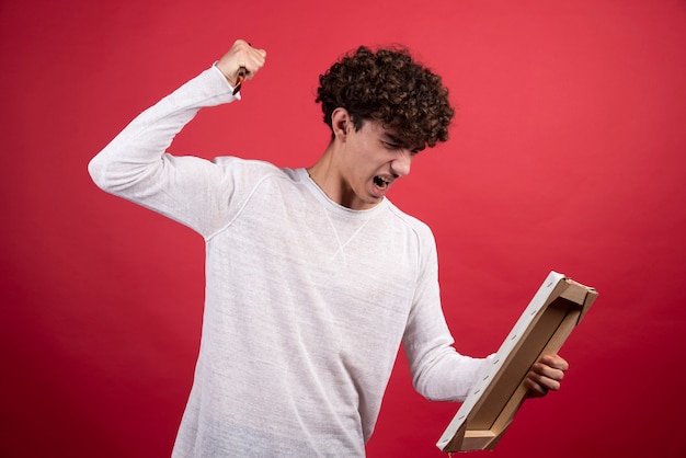 Free Photo angry curly man screaming at empty canvas.