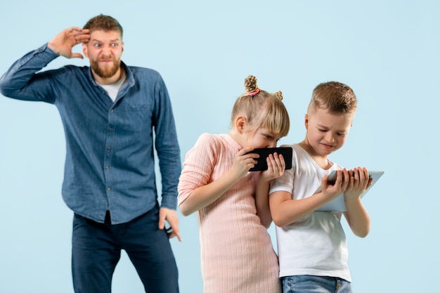 Angry father scolding his son and daughter at home.