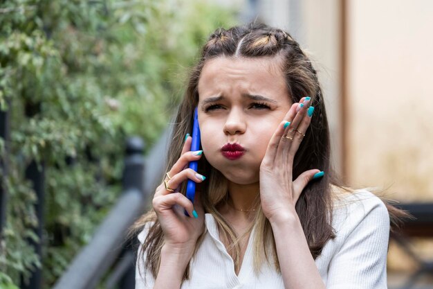 Angry girl talking on the phone and wrinkled her lips