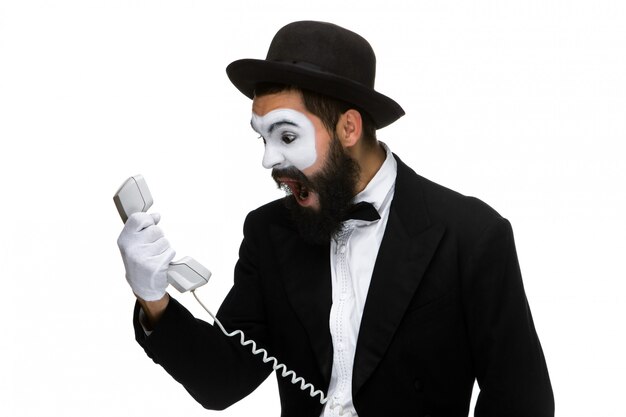 Angry and irritated  man screams into the telephone receiver