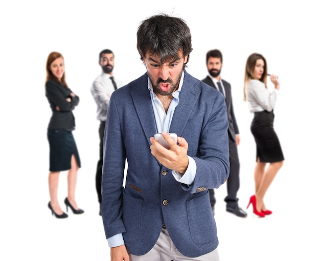 Angry man talking to mobile over white background