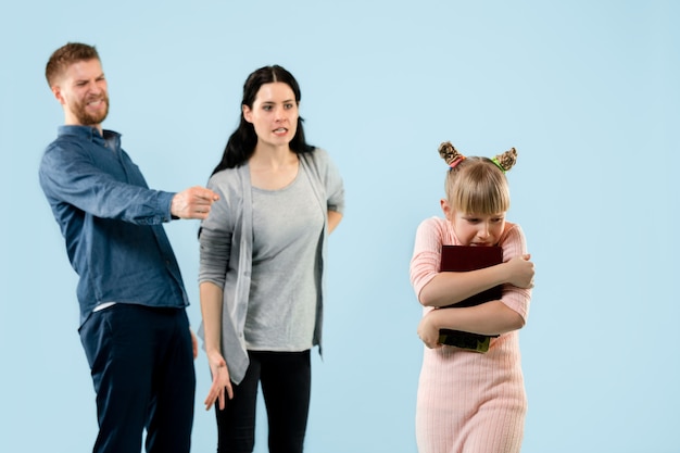 Angry parents scolding their daughter at home.