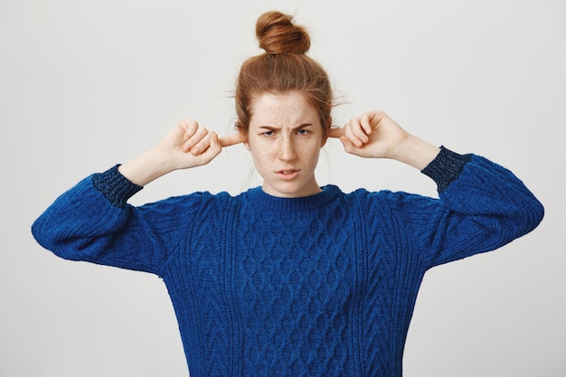 Angry redhead girl shut ears unwilling to listen