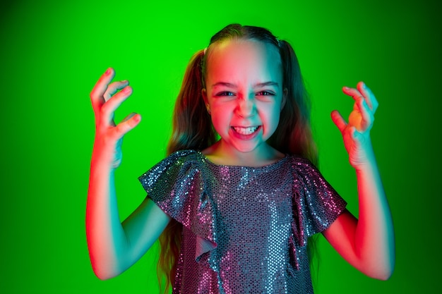 Angry teen girl standing on trendy green