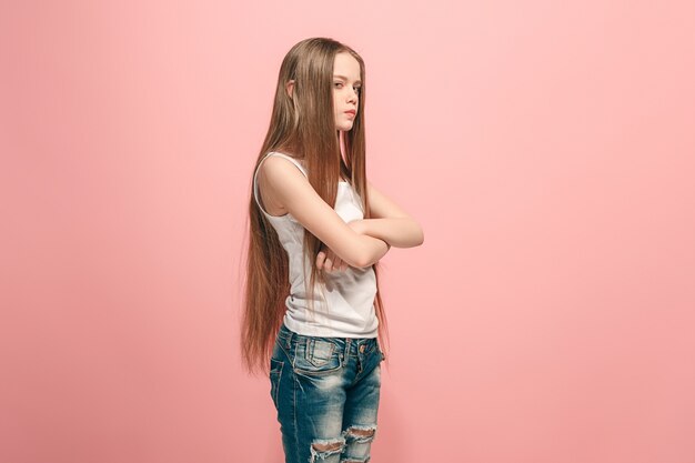 Angry teen girl standing on trendy pink studio.