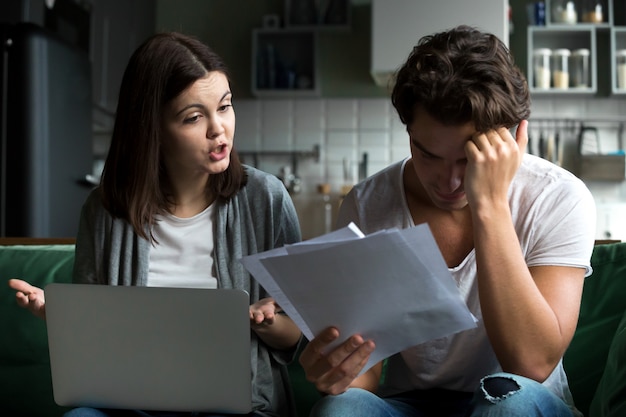 Angry wife scolding blaming upset husband of unpaid bills